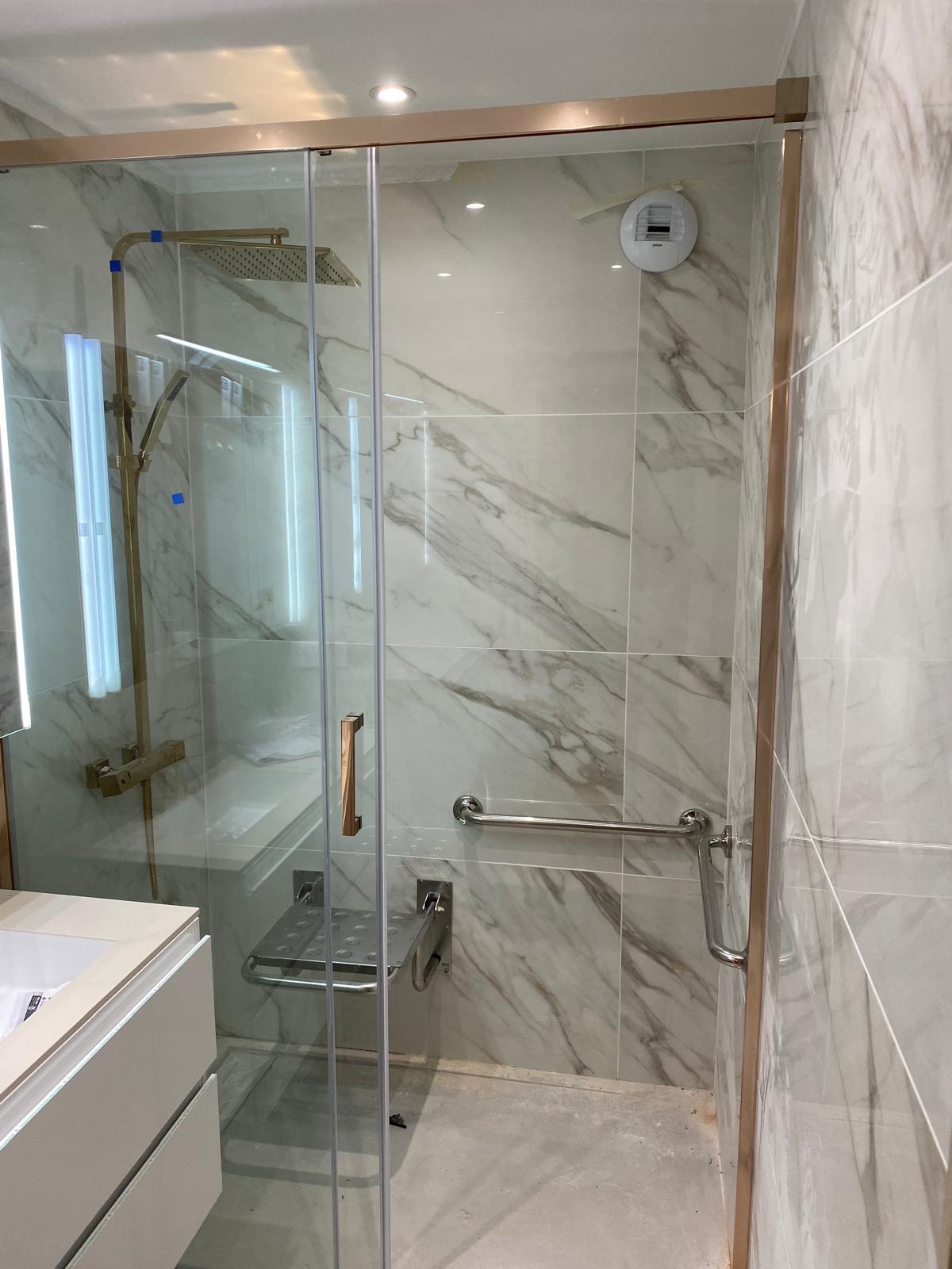 Adaptation PMR de la salle de bain avec douche à l'italienne, siège de douche et barres de maintien